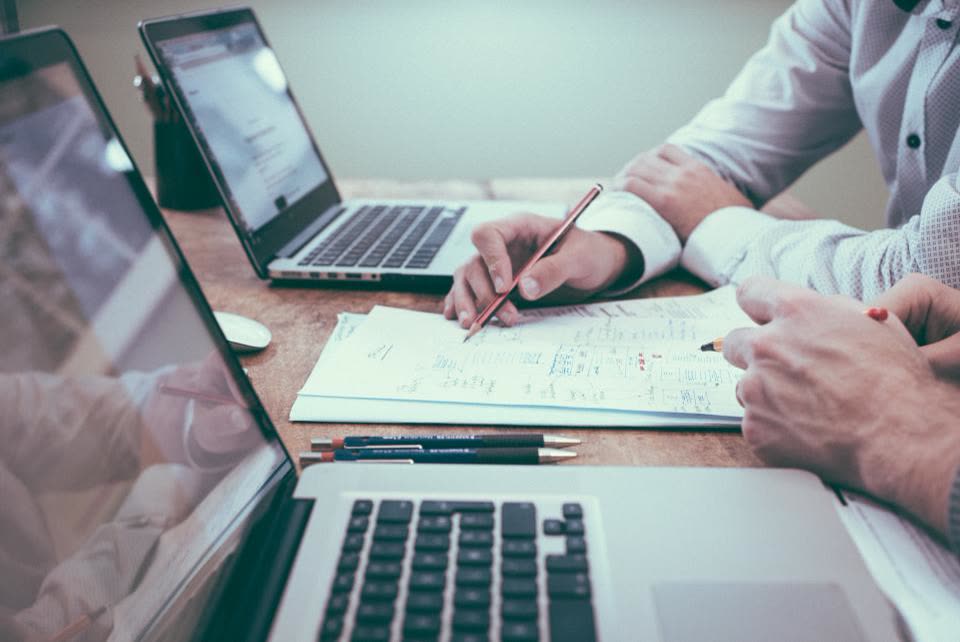 Two colleagues working through documents at a table