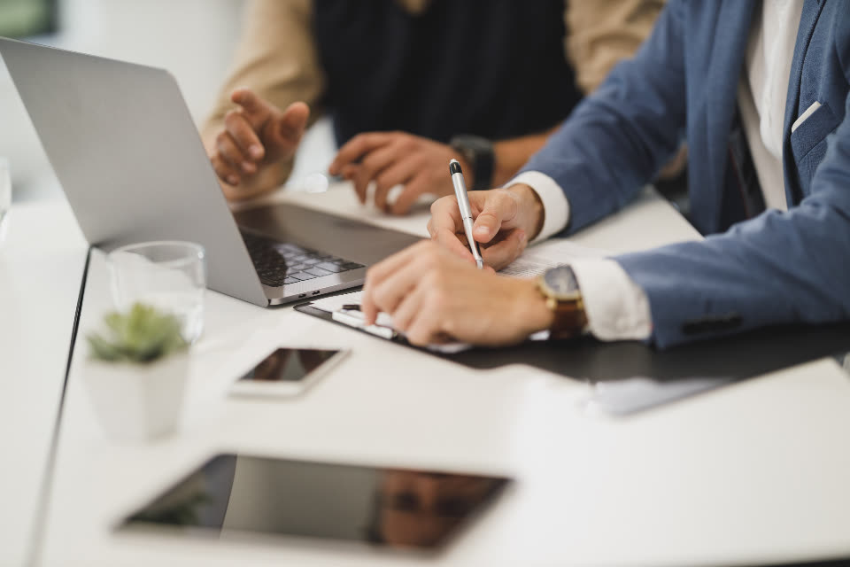 Client team reviewing notes and laptops at a table
